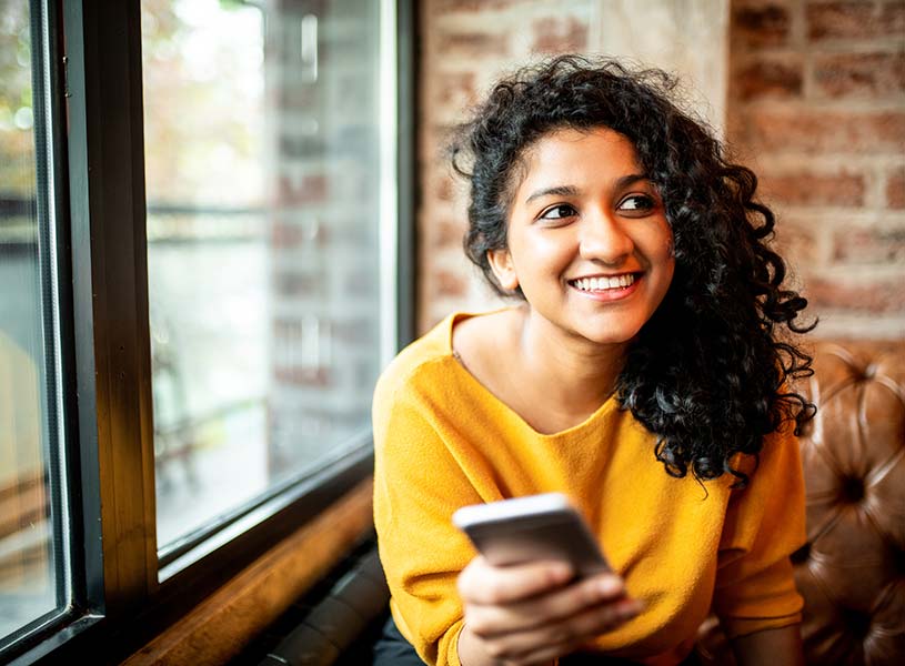 Young lady using a smartphone in an office building